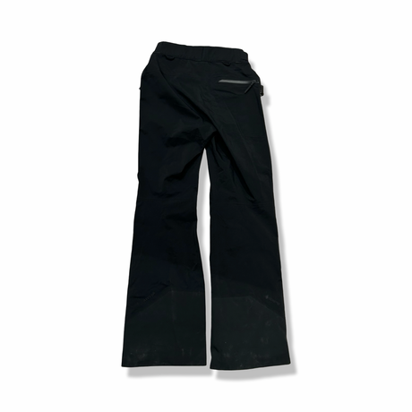Black Peak Performance women's Alpine Gore-Tex shell pants, back view against a white background.