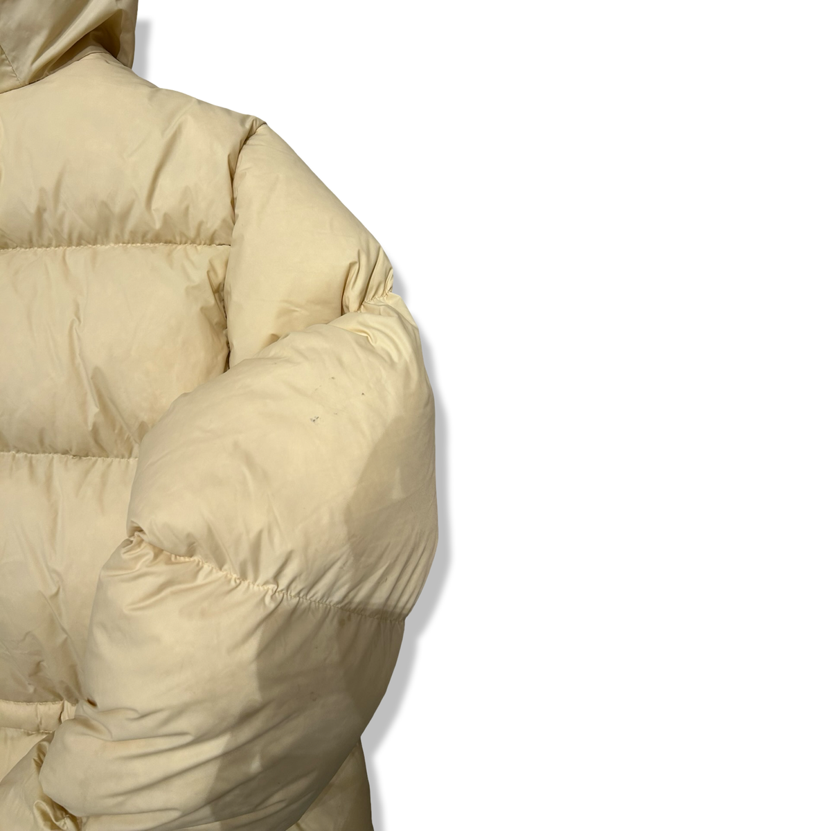 Yellow Peak Performance women's down hood parka, detailed view of the sleeve against a white background.