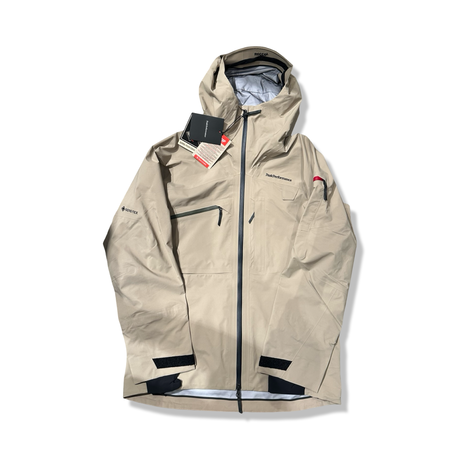 Beige skaljacka Peak Performance Alpine Gore-Tex för herr med huva och dragkedjor, fotograferad framifrån mot en vit bakgrund.