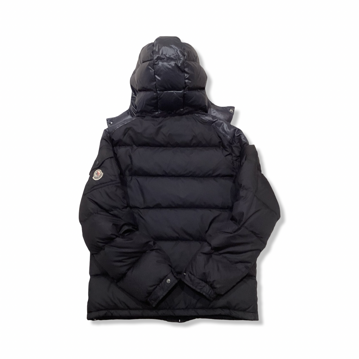 Back view of a blue Moncler hooded down jacket against a white background.