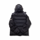 Back view of a blue Moncler hooded down jacket against a white background.