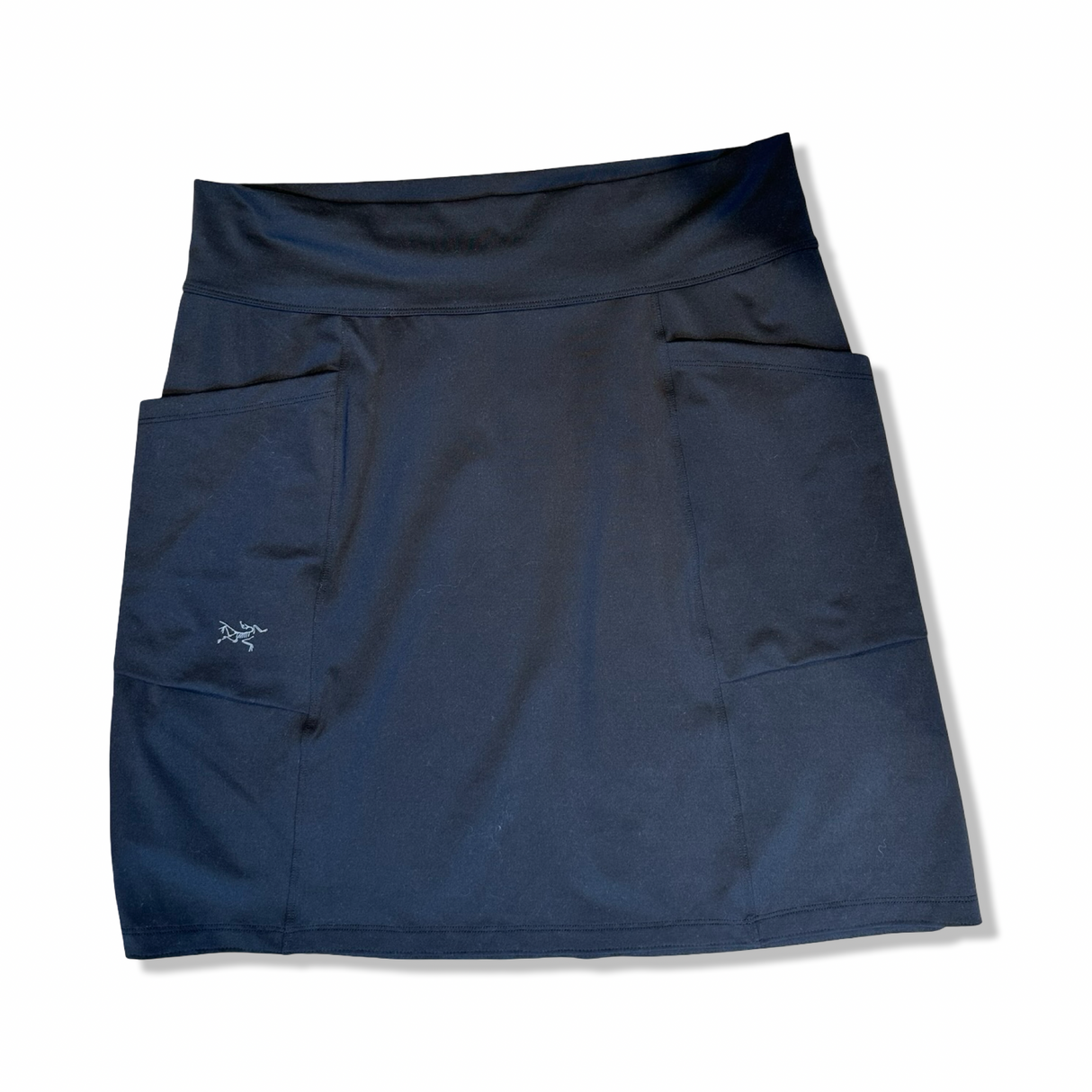 Svart Arc'teryx kjol för dam med fickor, fotograferad framifrån mot en vit bakgrund.