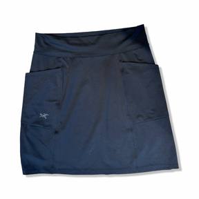 Svart Arc'teryx kjol för dam med fickor, fotograferad framifrån mot en vit bakgrund.