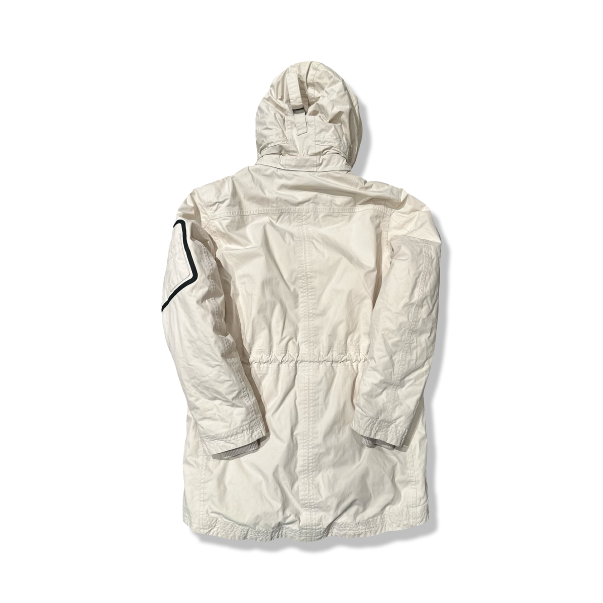 Baksidan av en beige parkas från Timberland för dam med huva, fotograferad mot en vit bakgrund.