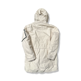 Baksidan av en beige parkas från Timberland för dam med huva, fotograferad mot en vit bakgrund.