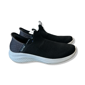 Black Skechers women's sneakers in model Ultra Flex 3.0 Smooth Step with a white sole against a white background.