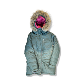 Grön dunjacka Peak Performance Style SWD Parka för dam med huva och pälsimitation, fotograferad framifrån mot vit bakgrund.