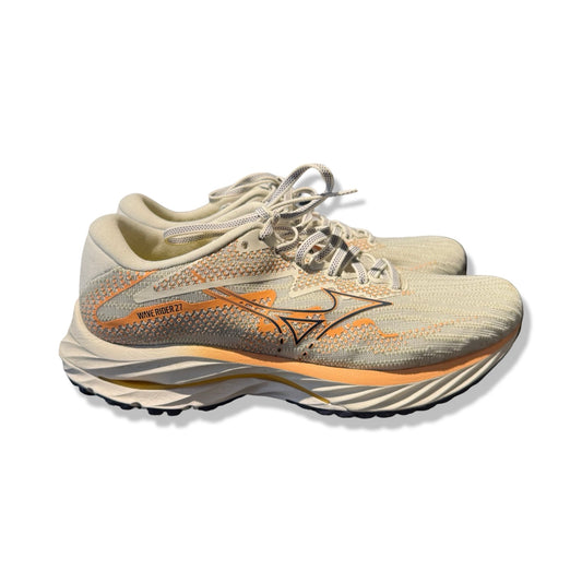 Mizuno Wave Rider 27 löparskor för dam i vitt med orange detaljer, sedda från sidan mot en vit bakgrund.