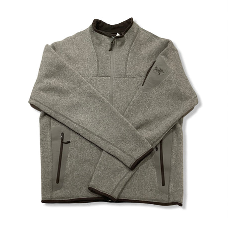 Beige fleececardigan från Arc'teryx för herr med dragkedja, fotograferad framifrån mot en vit bakgrund.