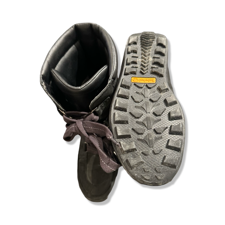 Underside and inside of a pair of black women's Timberland winter boots against a white background.