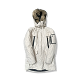 Beige parkas från Timberland för dam med huva och fuskpäls, fotograferad framifrån mot en vit bakgrund.