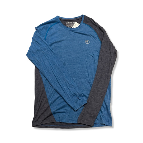 Blue and dark grey Ortovox Rock'N'Wool men's long sleeve base layer, front view against a white background.