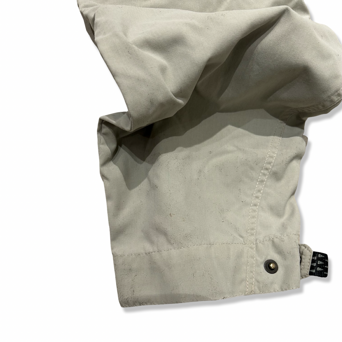 Närbild på ett ben på ett par beige Haglöfs funktionsbyxor för herr, visat mot en vit bakgrund.