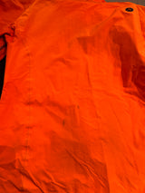 Close-up of the back of an orange Marmot men's shell jacket, showing stains on the back.
