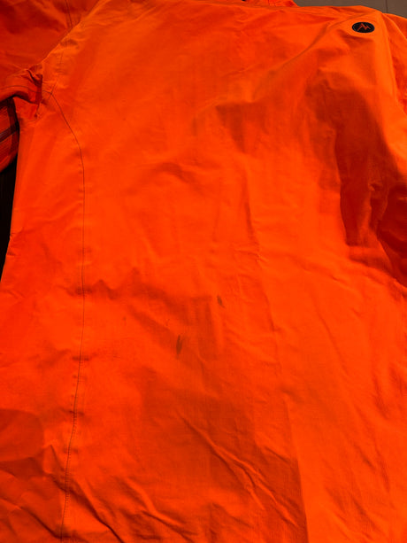Close-up of the back of an orange Marmot men's shell jacket, showing stains on the back.