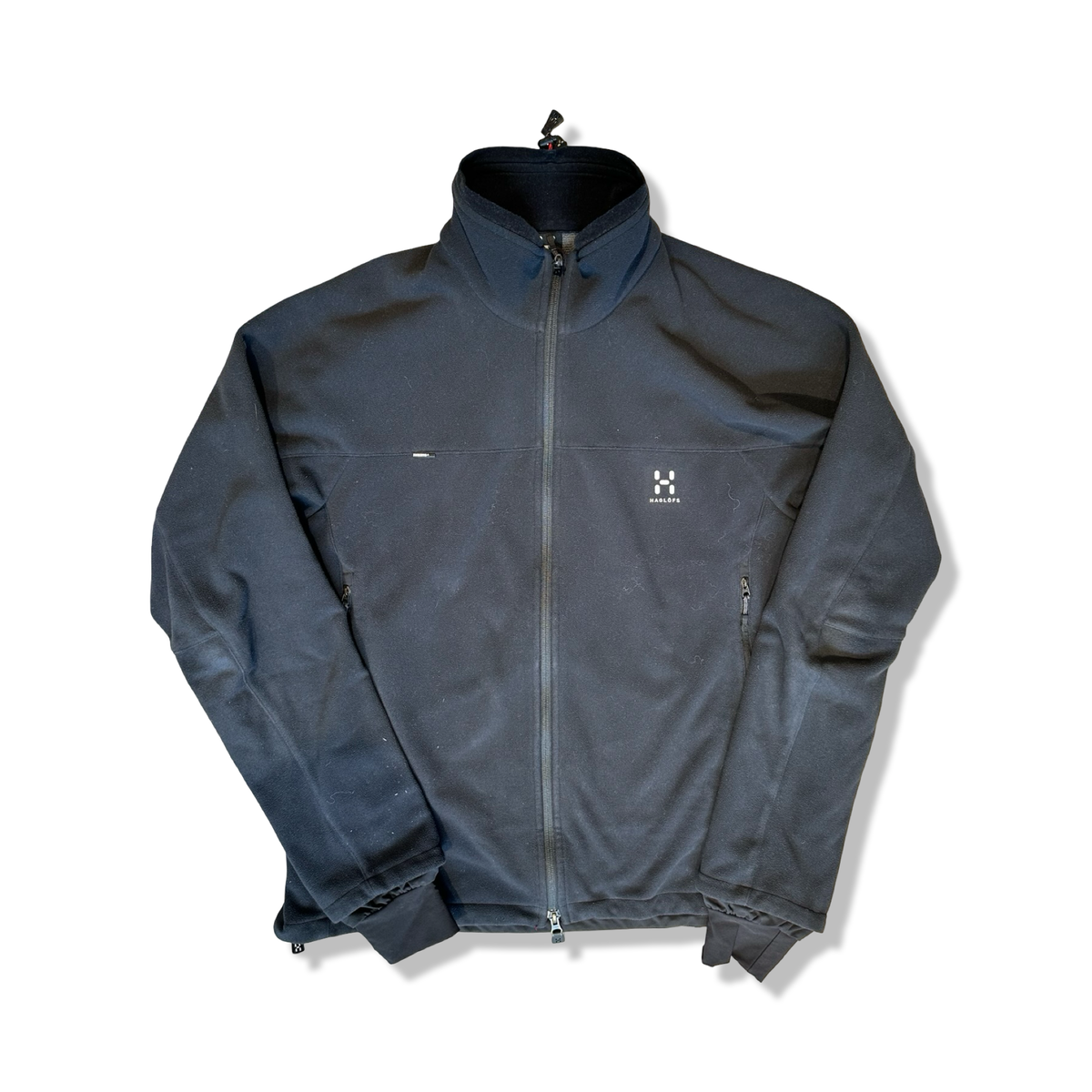 Svart windstopperjacka från Haglöfs för herr med hög krage och dragkedja, fotograferad framifrån mot en vit bakgrund.