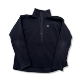 Black Haglöfs Mora mid women's fleece sweater with snap buttons, front view against a white background.