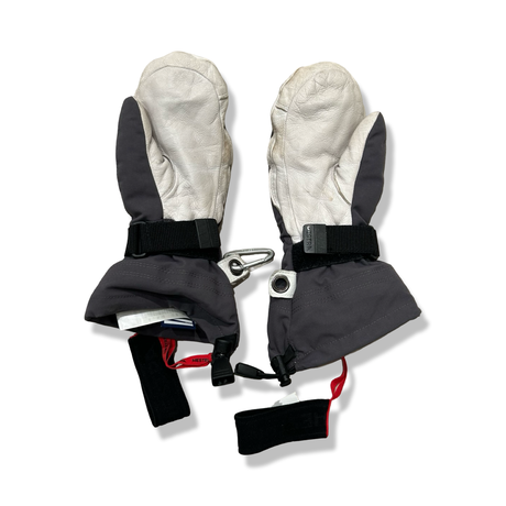 Blue and white Hestra mittens with straps and a carabiner against a white background.