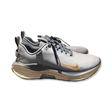 Grey Nike Infinity 4 GTX unisex running shoes with gold details, side view against a white background.