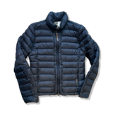 Blå dunjacka från Woolrich i storlek L, fotograferad framifrån mot en vit bakgrund.