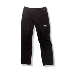 Black The North Face men's softshell trousers with zippered pockets, front view against a white background.
