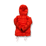 Back view of an orange Nike ACG women's hooded down jacket against a white background.