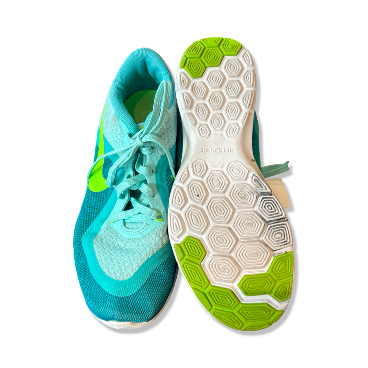 Turkosa träningsskor Nike Flex Trainer 6 för dam med mönstrad sula, fotograferade uppifrån mot en vit bakgrund.