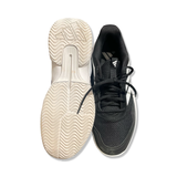 Black and white Adidas Gamecourt men's running shoes, showing a sole and an upper against a white background.
