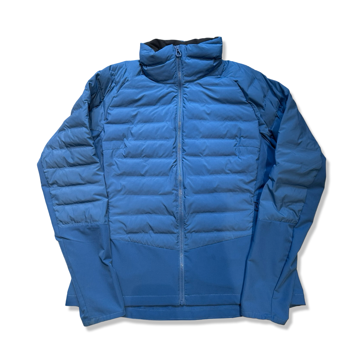 Blå Helly Hansen dunjacka för dam i storlek XL, fotograferad framifrån mot en vit bakgrund.