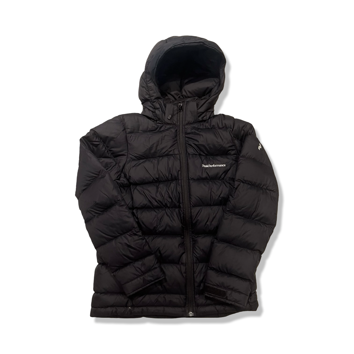 Svart dunjacka från Peak Performance JR Frost Down Jacket för junior, fotograferad framifrån mot en vit bakgrund.