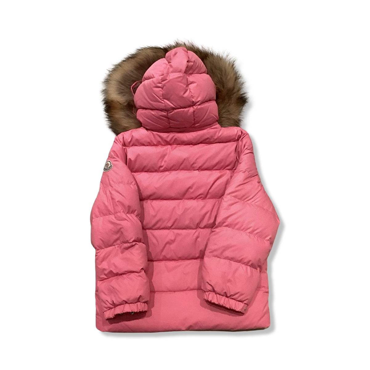 Baksidan av en rosa dunjacka från Moncler med huva och pälskant för barn, fotograferad mot en vit bakgrund.