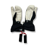 Black and white Hestra gloves with leather details and wrist straps, photographed against a white background.