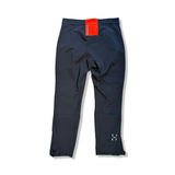 Back view of a pair of black Haglöfs L.I.M Series Z women's performance trousers with an orange waistband detail, photographed against a white background.