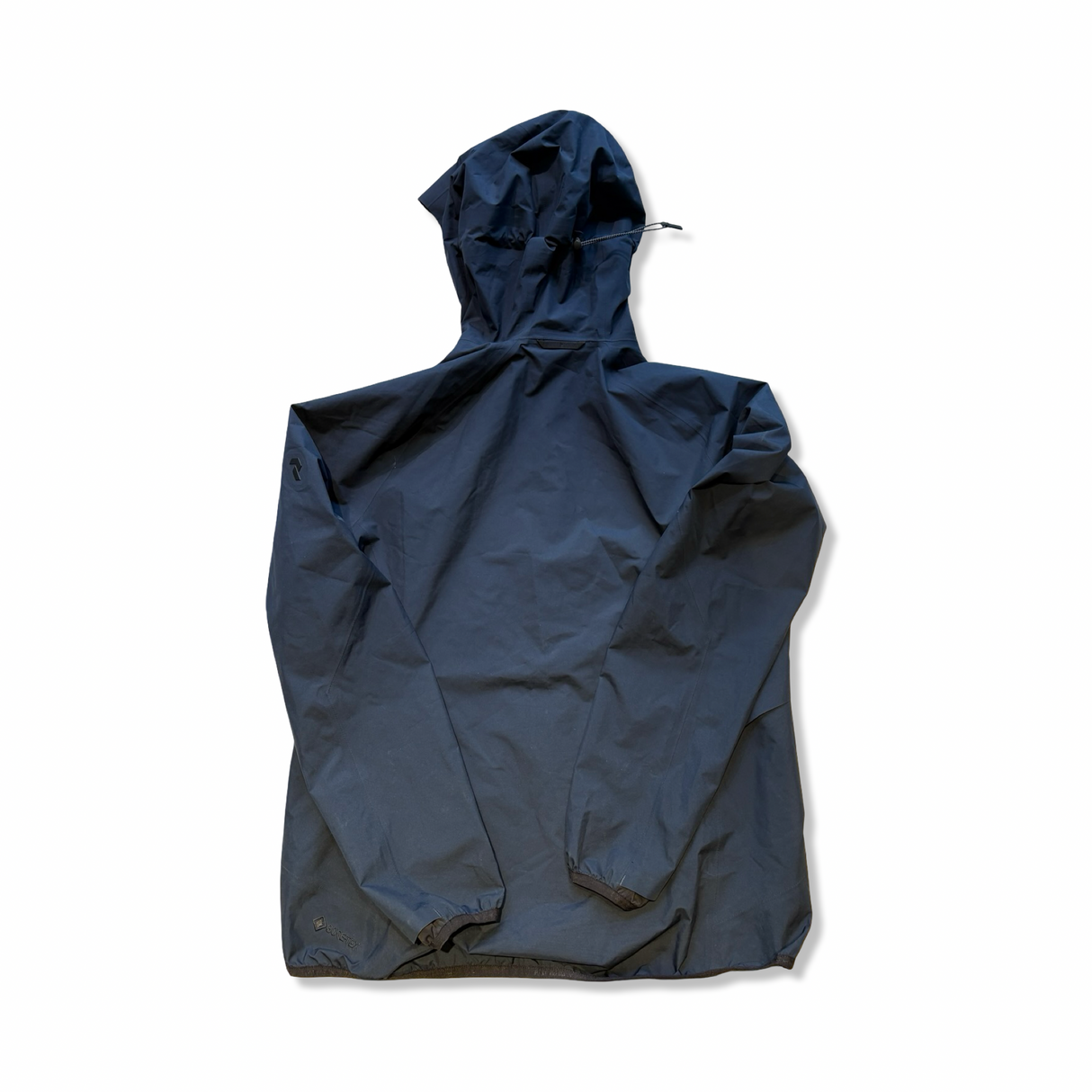 Baksidan av en mörkblå skaljacka från Peak Performance för dam i modell Gore-Tex Pac, visad mot vit bakgrund.