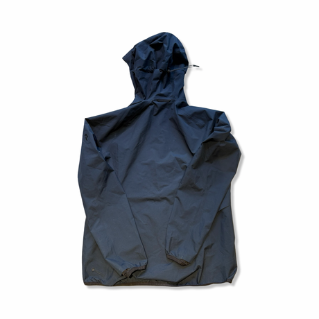 Baksidan av en mörkblå skaljacka från Peak Performance för dam i modell Gore-Tex Pac, visad mot vit bakgrund.