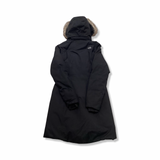Back view of a black The North Face women's down jacket with a fur-trimmed hood against a white background.