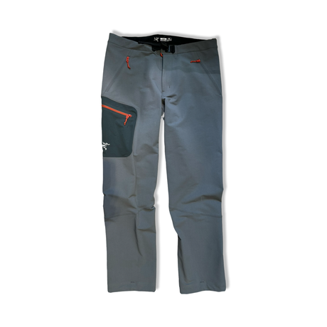 Grey Arc'teryx Gamma MX men's softshell pants with orange zippers, front view against a white background.
