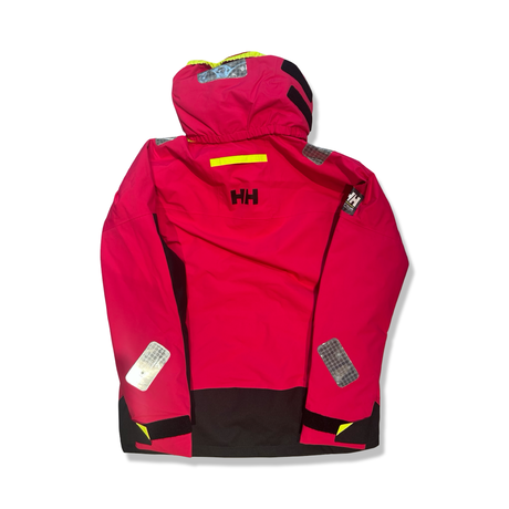 Baksidan av en rosa och svart Helly Hansen Skagen offshore seglarjacka för dam med huva, fotograferad mot en vit bakgrund.