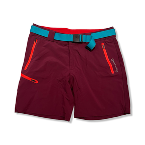 Lila vandringsshorts från Ortovox för dam med turkost bälte och orangea detaljer, fotograferade framifrån mot en vit bakgrund.