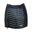 Black The North Face women's insulated skirt with side zipper, front view against a white background.