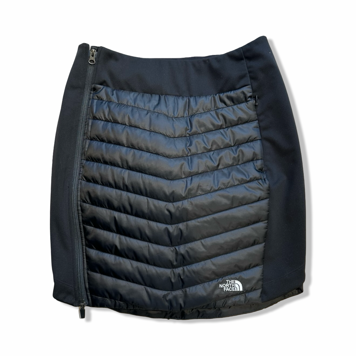 Black The North Face women's insulated skirt with side zipper, front view against a white background.