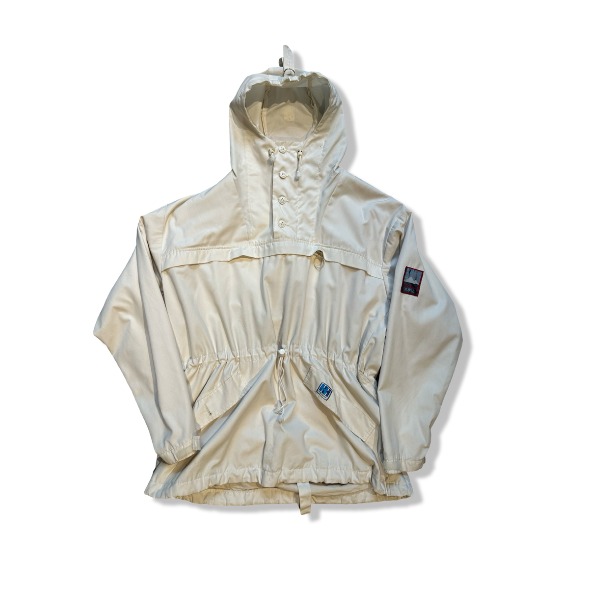 Vit Helly Hansen retro anorak med huva och dragsko i midjan, fotograferad framifrån mot vit bakgrund.