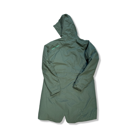 Baksidan av en grön Kari Traa Helena parkas för dam med huva, fotograferad mot en vit bakgrund.