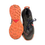 Svarta damlöparskor av modellen Nike Pegasus Trail Gore-Tex, visade uppifrån och med sulan vänd uppåt mot vit bakgrund.