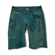 Gröna damshorts från Outdoor Research med blixtlåsfickor, fotograferade framifrån mot en vit bakgrund.