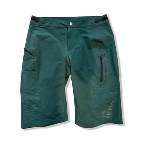 Gröna damshorts från Outdoor Research med blixtlåsfickor, fotograferade framifrån mot en vit bakgrund.