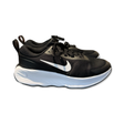 Black Nike Promina women's running shoes with a white sole and white swoosh logo, photographed from the side against a white background.