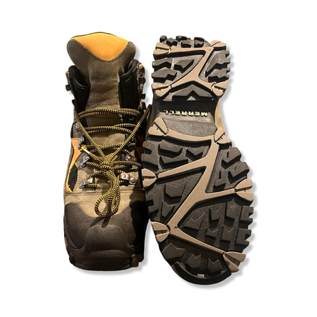 A pair of brown Merrell men's hiking boots, shown from the front and with the sole against a white background.