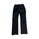 Black softshell hiking pants with reinforced panels and buttons at the hems, back view on a white background.