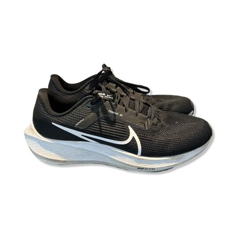 Svarta Nike Pegasus 40-löparskor för unisex med vit sula och vit Nike-svep, fotograferade från sidan.